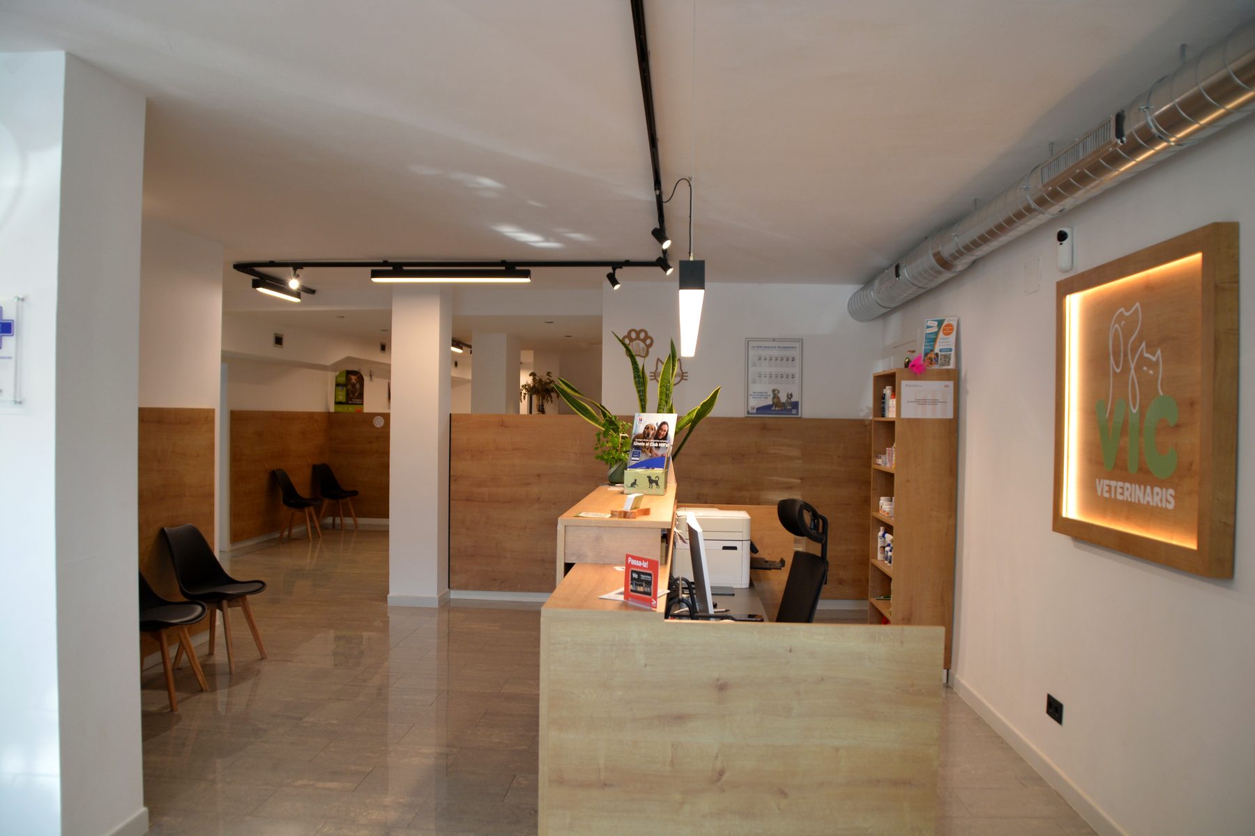Recepció de Vic Veterinaris amb la sala d'espera i el logotip il·luminat